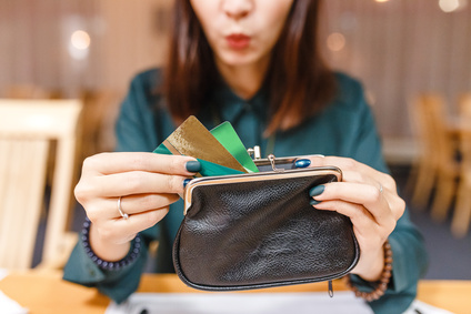 Surprised woman taken out from wallet two credit cards, cashback concept