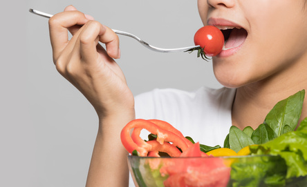 Young woman biting a salad.