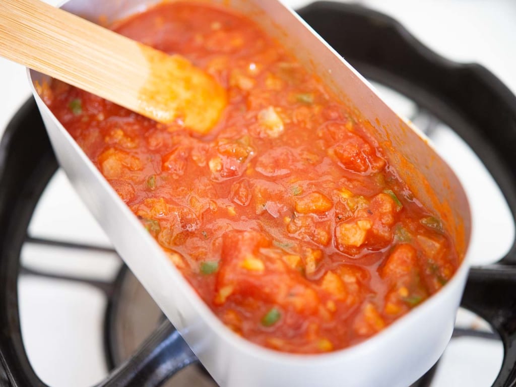 トマト缶を加えて沸騰させ、とろみが出るまで水分を飛ばしながら5分ほど煮詰めましょう