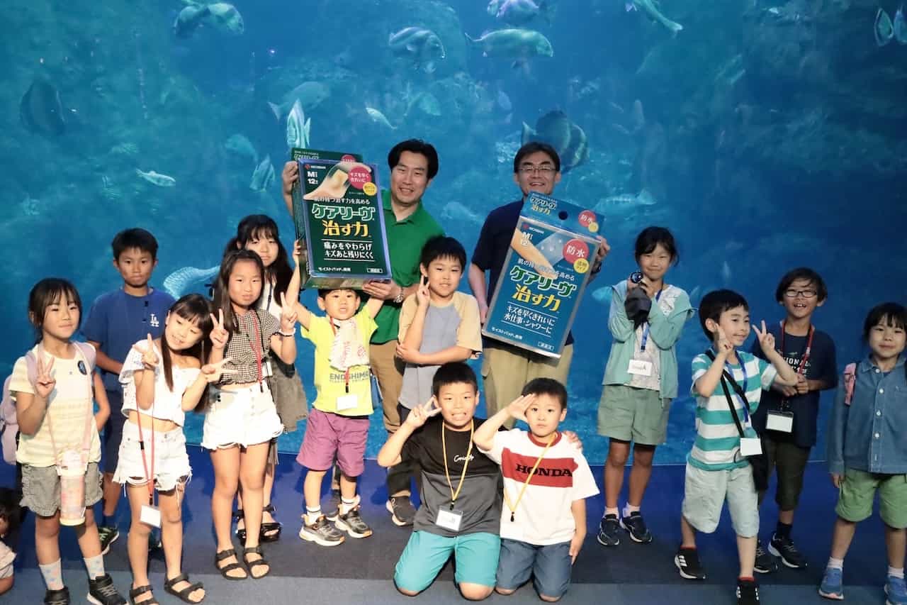 ニチバン事業戦略本部の倉智一さん、新江ノ島水族館えのすいトリーター・杉村誠さんと子どもたち